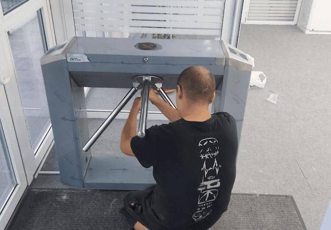 мастер чинит турникет