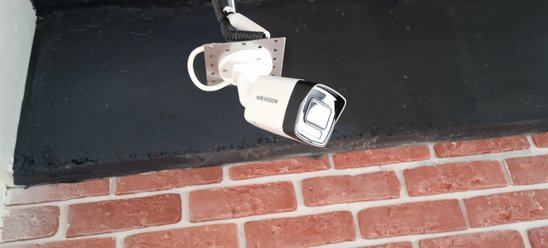 IP-камера Hikvision под потолком у кирпичной стены